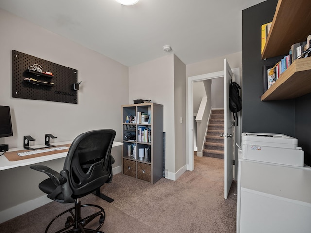 office featuring baseboards and light carpet