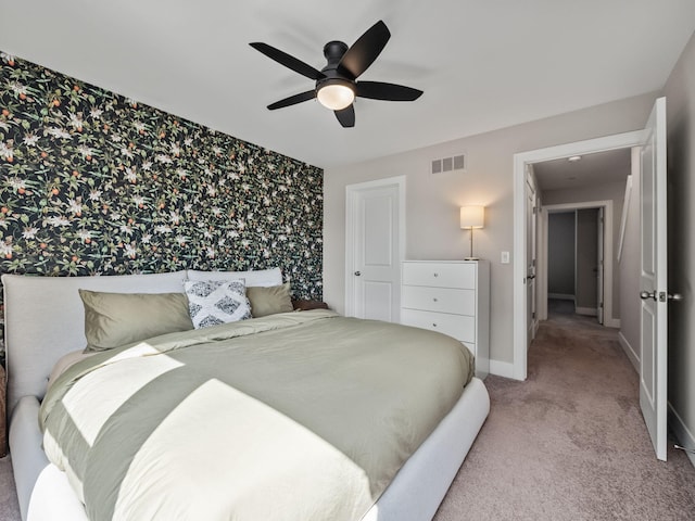 bedroom featuring visible vents, carpet, baseboards, wallpapered walls, and a ceiling fan