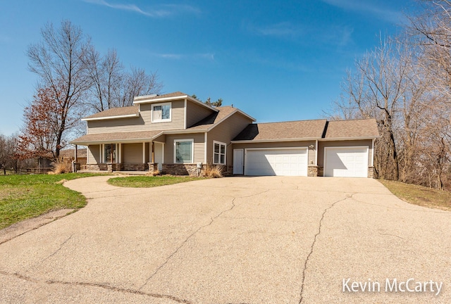 view of front of home featuring stone siding, a garage, concrete driveway, roof with shingles, and covered porch