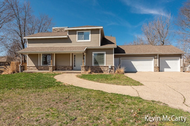 view of front of property with stone siding, an attached garage, a front lawn, driveway, and covered porch