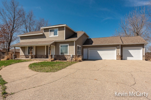 view of front of property with covered porch, stone siding, roof with shingles, concrete driveway, and an attached garage