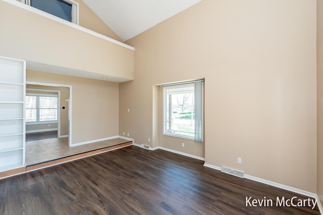 unfurnished room featuring dark wood-style floors, visible vents, high vaulted ceiling, and baseboards