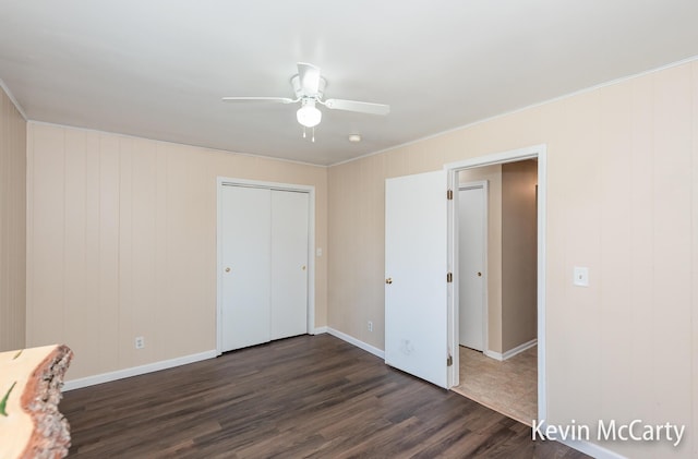 unfurnished bedroom featuring a ceiling fan, dark wood-style floors, a closet, and baseboards
