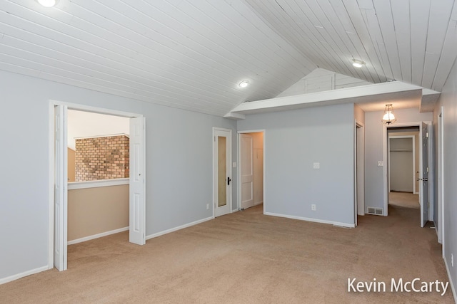unfurnished bedroom featuring lofted ceiling, wooden ceiling, baseboards, visible vents, and light carpet