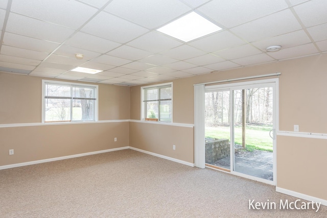 unfurnished room with baseboards, a healthy amount of sunlight, and a paneled ceiling