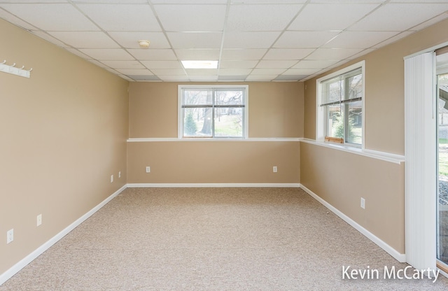 unfurnished room with baseboards, carpet floors, and a paneled ceiling