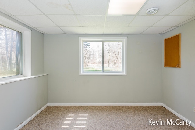 unfurnished room with baseboards, carpet floors, and a drop ceiling