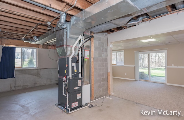 below grade area featuring heating unit and plenty of natural light