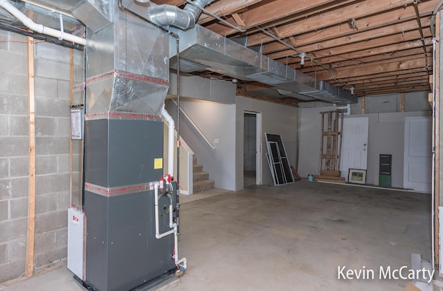 unfinished basement with stairs and heating unit