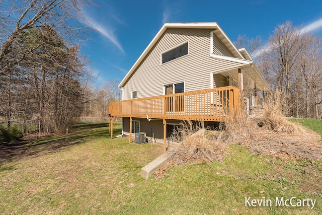 back of property with a wooden deck, central AC, and a lawn