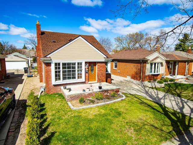 view of front of house featuring brick siding, a front yard, fence, and an outdoor structure