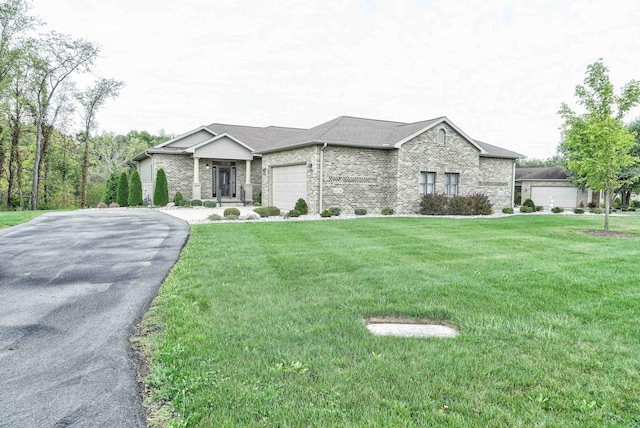 4274 Evergreen Rd Unit 14, Adrian, MI 49221 - view of front of house featuring aphalt driveway, a front yard, a garage, and brick siding