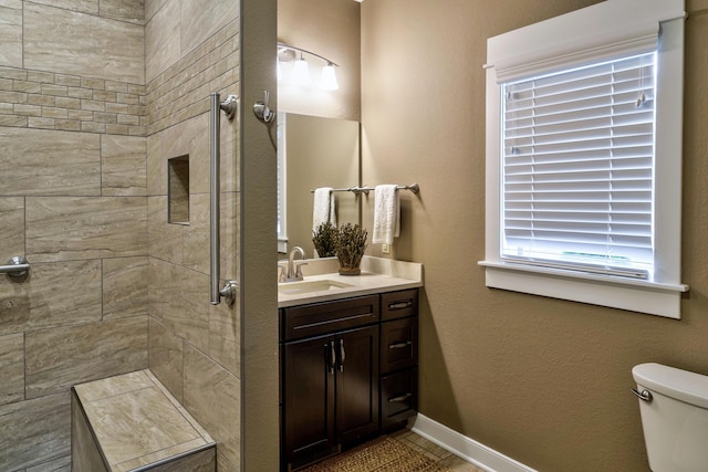 4274 Evergreen Rd Unit 14, Adrian, MI 49221 - bathroom featuring a tile shower, vanity, tile patterned flooring, toilet, and baseboards