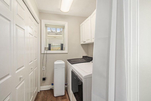 washroom featuring washing machine and clothes dryer, cabinet space, baseboards, and dark wood finished floors