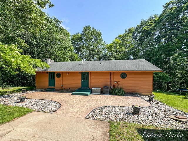 3770 Pine Ln, Saranac, MI 48881 - rear view of house with a trampoline, entry steps, a patio, a lawn, and a chimney