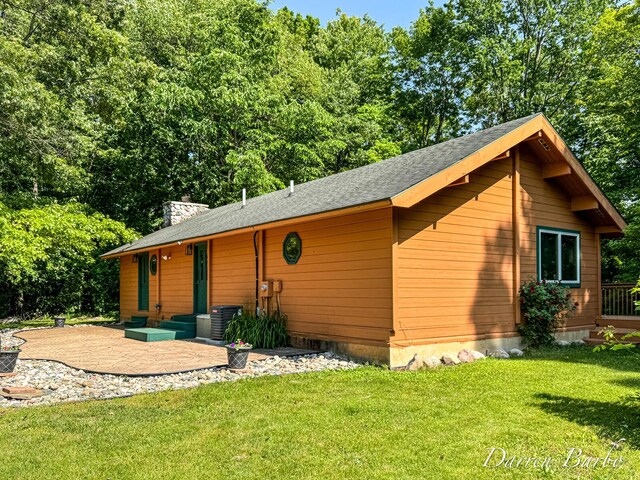 3770 Pine Ln, Saranac, MI 48881 - view of front of home with a front yard, a chimney, a patio area, and roof with shingles