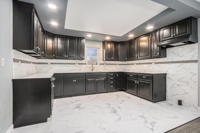 101 E 4th St, Buchanan, MI 49107 - kitchen with recessed lighting, decorative backsplash, a sink, and a raised ceiling