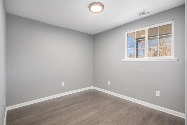 101 E 4th St, Buchanan, MI 49107 - spare room with dark wood-type flooring, visible vents, and baseboards