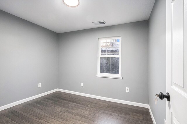 101 E 4th St, Buchanan, MI 49107 - spare room featuring dark wood-style floors, visible vents, and baseboards