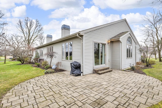 4284 Fairway Ln, Jackson, MI 49201 - back of property with entry steps, a chimney, a patio area, and a lawn