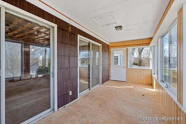 unfurnished sunroom featuring wooden walls