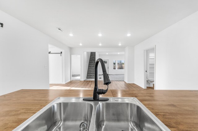 10282 7 Mile Rd, Evart, MI 49631 - room details featuring visible vents, recessed lighting, wood finished floors, and a sink
