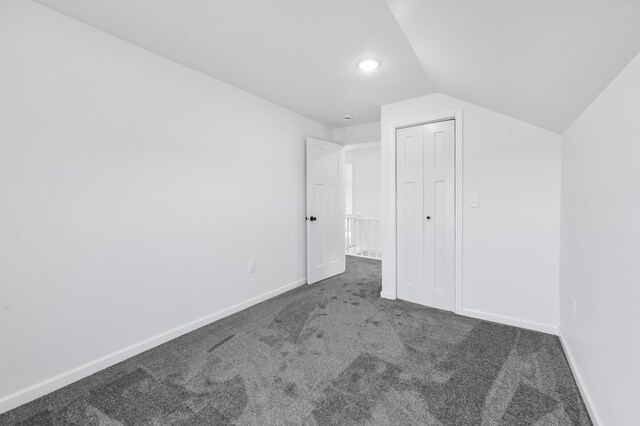 10282 7 Mile Rd, Evart, MI 49631 - unfurnished bedroom featuring baseboards, carpet flooring, lofted ceiling, and a closet