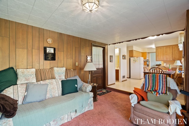 living area featuring light colored carpet and wood walls