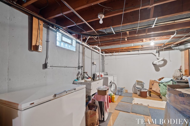 below grade area with white refrigerator and washer and clothes dryer