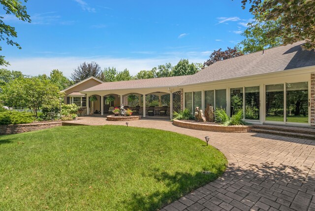 6130 Eidson Rd, Saint Joseph, MI 49085 - rear view of property featuring a yard, a patio, and roof with shingles