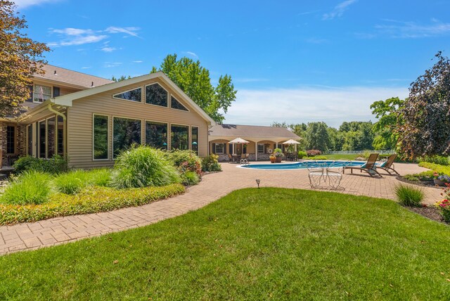 6130 Eidson Rd, Saint Joseph, MI 49085 - rear view of property with a patio, a lawn, and an outdoor pool