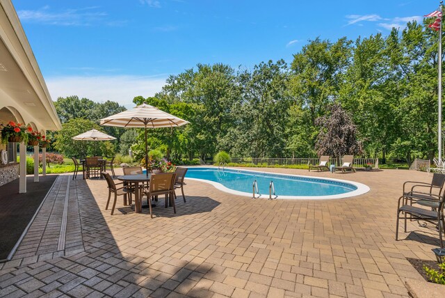 6130 Eidson Rd, Saint Joseph, MI 49085 - view of pool featuring a patio, view of wooded area, and outdoor dining area