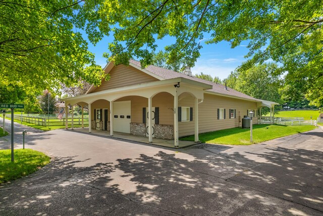 6130 Eidson Rd, Saint Joseph, MI 49085 - view of front of home featuring asphalt driveway, roof with shingles, an attached garage, and a chimney