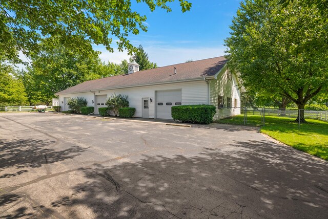 6130 Eidson Rd, Saint Joseph, MI 49085 - view of side of property featuring a garage and roof with shingles