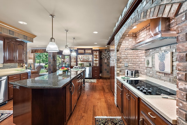 6130 Eidson Rd, Saint Joseph, MI 49085 - kitchen featuring black electric cooktop, wall chimney range hood, tasteful backsplash, a center island, and wood finished floors