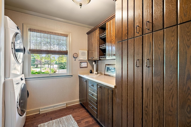 6130 Eidson Rd, Saint Joseph, MI 49085 - laundry area with cabinet space, estacked washer and dryer, baseboards, crown molding, and dark wood finished floors