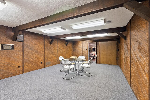 6130 Eidson Rd, Saint Joseph, MI 49085 - dining area featuring wood walls, beam ceiling, a textured ceiling, and carpet flooring