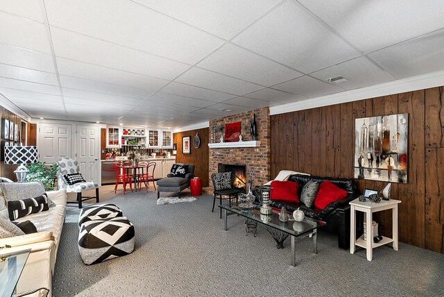 6130 Eidson Rd, Saint Joseph, MI 49085 - living area with carpet, a drop ceiling, wooden walls, and a fireplace