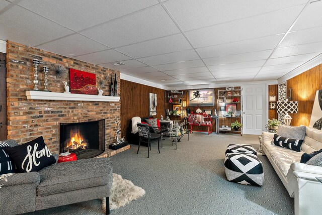 6130 Eidson Rd, Saint Joseph, MI 49085 - carpeted living room with wood walls, a fireplace, and a paneled ceiling