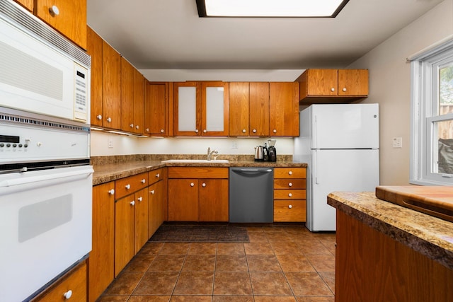 1506 Hillridge Blvd, Ann Arbor, MI 48103 - kitchen with glass insert cabinets, a sink, dark countertops, white appliances, and brown cabinets