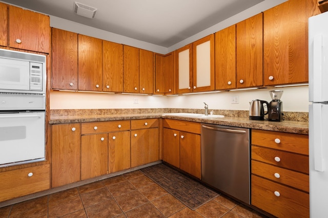 1506 Hillridge Blvd, Ann Arbor, MI 48103 - kitchen featuring dark tile patterned floors, white appliances, visible vents, brown cabinets, and a sink