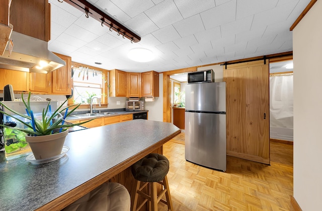 306 Eubank St, Novi, MI 48377 - kitchen with appliances with stainless steel finishes, a sink, dark countertops, rail lighting, and wall chimney range hood