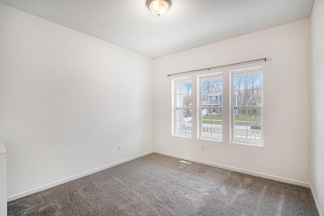 7434 Bramling Dr SE, Caledonia, MI 49316 - spare room featuring carpet, visible vents, and baseboards