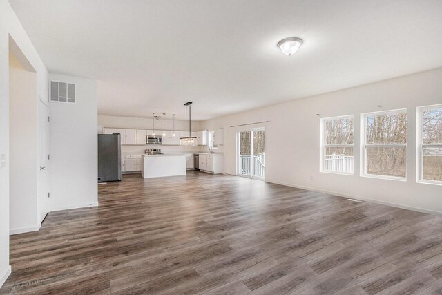 7434 Bramling Dr SE, Caledonia, MI 49316 - unfurnished living room with visible vents, baseboards, and dark wood finished floors