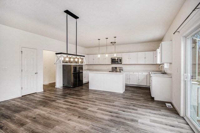 7434 Bramling Dr SE, Caledonia, MI 49316 - kitchen featuring a center island, dark wood-style flooring, light countertops, a sink, and stainless steel appliances