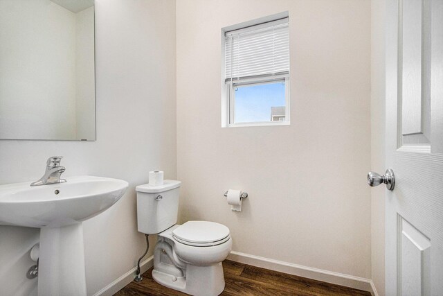7434 Bramling Dr SE, Caledonia, MI 49316 - half bath featuring baseboards, a sink, toilet, and wood finished floors