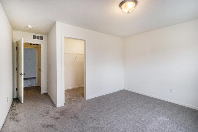 7434 Bramling Dr SE, Caledonia, MI 49316 - unfurnished bedroom with a closet, baseboards, carpet floors, a walk in closet, and visible vents