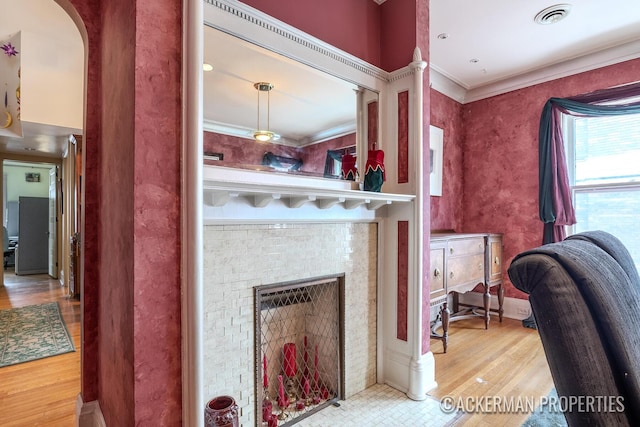 234 Madison Ave SE, Grand Rapids, MI 49503 - details with ornamental molding, a fireplace, visible vents, arched walkways, and wood finished floors