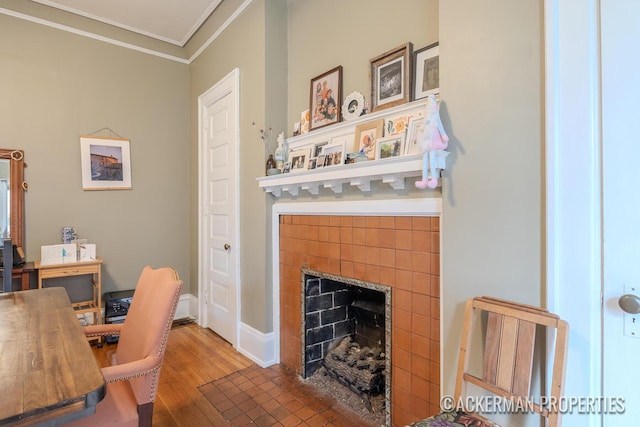 234 Madison Ave SE, Grand Rapids, MI 49503 - home office featuring a tiled fireplace, ornamental molding, baseboards, and wood finished floors