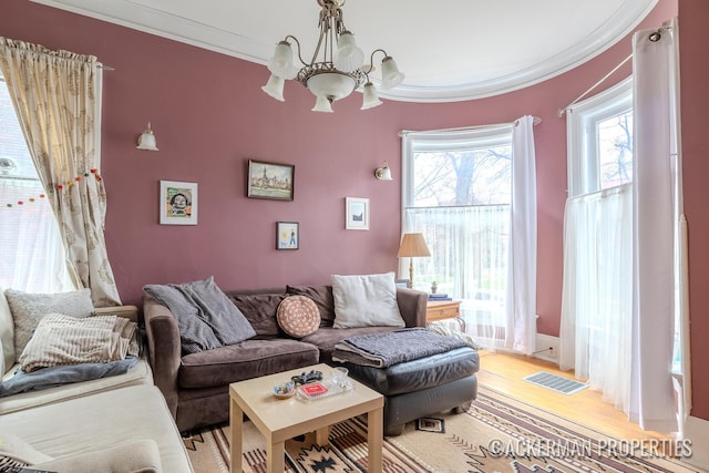234 Madison Ave SE, Grand Rapids, MI 49503 - living room featuring a chandelier, visible vents, ornamental molding, and light wood-style flooring